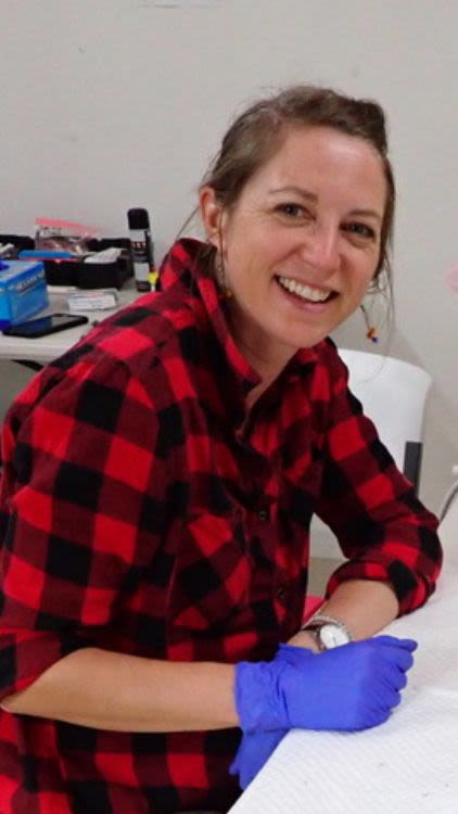 Woman sits at desk wearing gloves